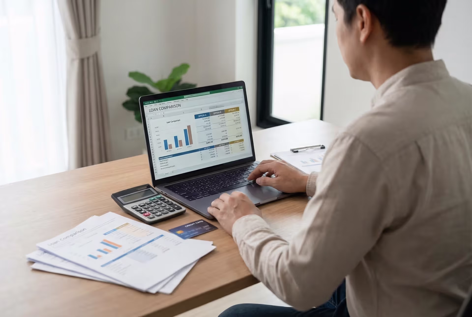 Person reviewing unsecured loan options on a laptop with financial documents and calculator